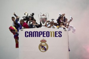 TOPSHOT - Real Madrid players hold up the trophy celebrating the team's win as they arrive by bus on Plaza Cibeles in Madrid on May 29, 2016 after the UEFA Champions League final foobtall match between Real Madrid CF, Club Atletico de Madrid held in Milan, Italy. / AFP / JAVIER SORIANO        (Photo credit should read JAVIER SORIANO/AFP/Getty Images)
