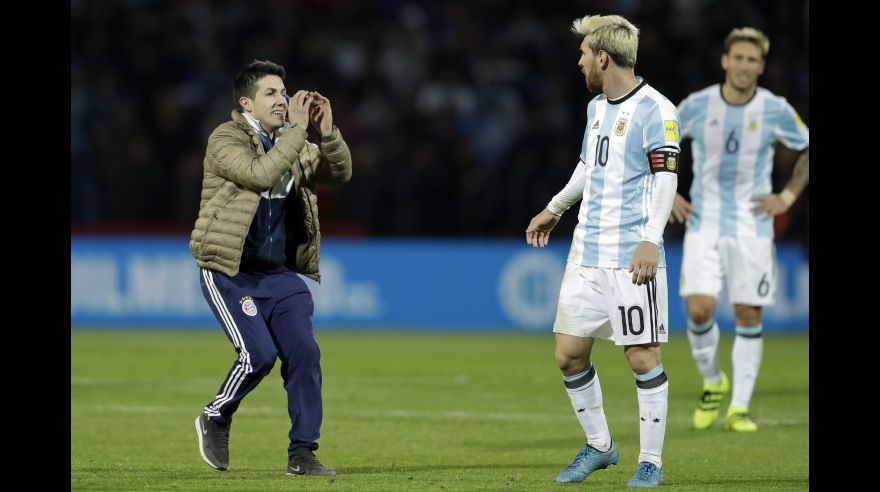 A fan who invaded the pitch gestures to Argentina's Lionel Messi, center, during a 2018 World Cup qualifying soccer match against Uruguay in Mendoza, Argentina, Thursday, Sept. 1, 2016.(AP Photo/Victor R. Caivano)