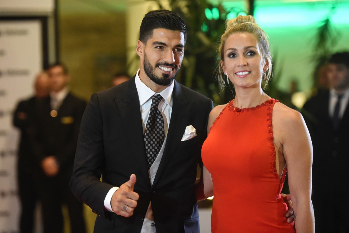 Uruguayan football player Luis Suarez and his wife Sofia Balbi pose on a red carpet during Barcelona's football star Lionel Messi and Antonella Roccuzzo wedding in Rosario, Santa Fe province, Argentina on June 30, 2017. Footballers and celebrities including pop singer Shakira gathered Friday for the "wedding of the century" in Lionel Messi's Argentine hometown as the Barcelona superstar prepared to marry his childhood sweetheart Antonella Roccuzzo. / AFP PHOTO / EITAN ABRAMOVICH